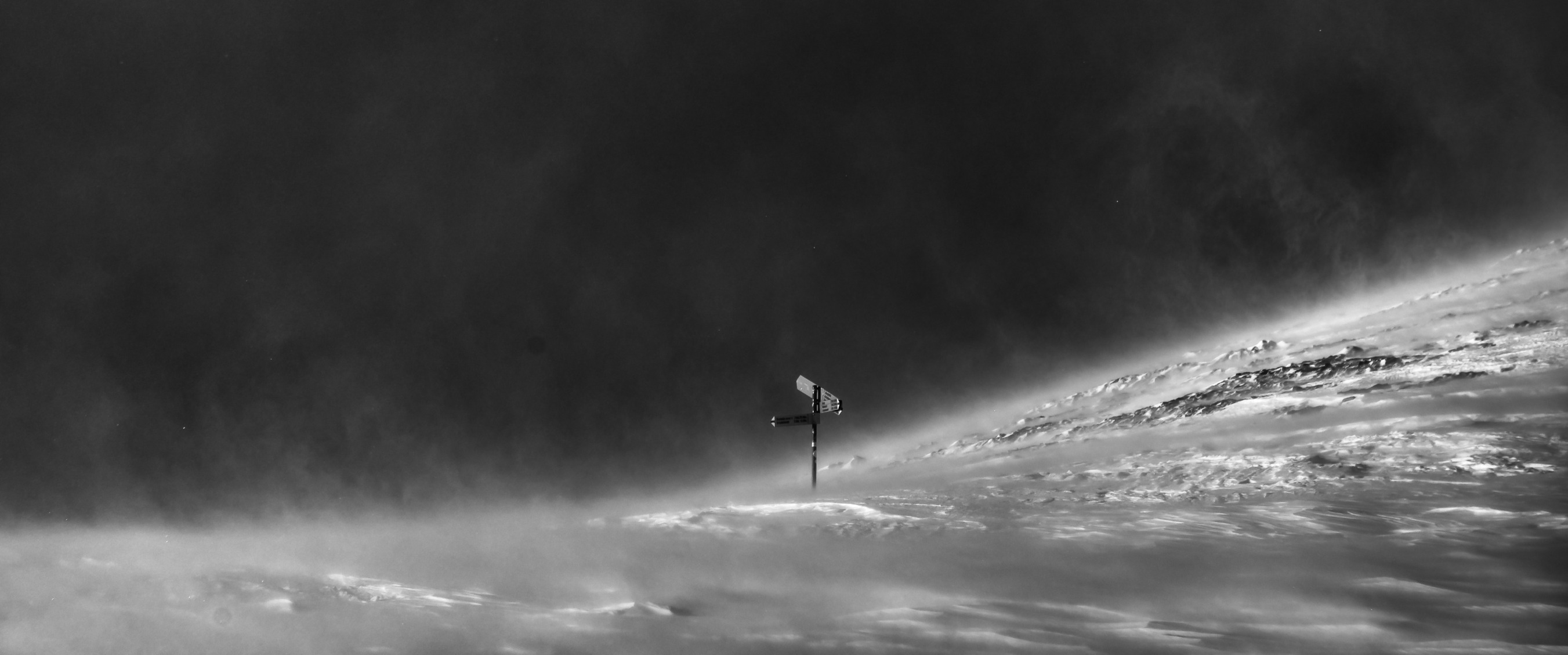 Signpost on a Swiss mountain ridge in blowing snow